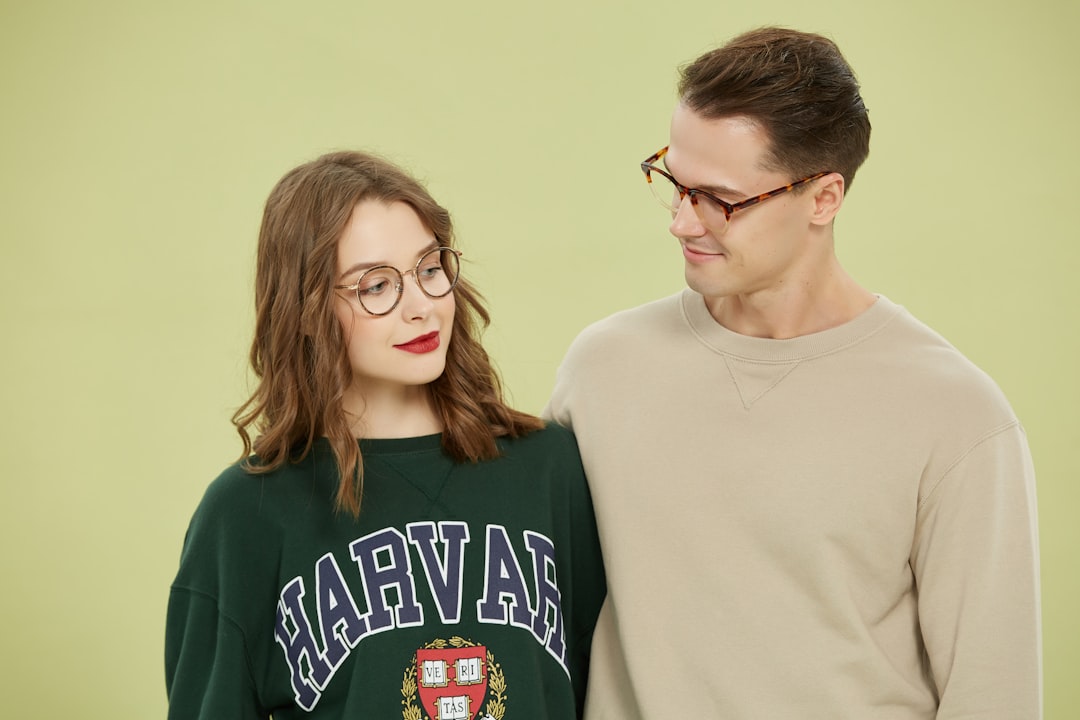 This stylish duo showcases the versatility and charm of modern eyewear. The man wears tortoiseshell rectangular frames that exude confidence and a classic aesthetic, perfect for both casual and professional settings. The woman complements him with delicate round metal glasses that add a vintage touch to her effortless denim look.