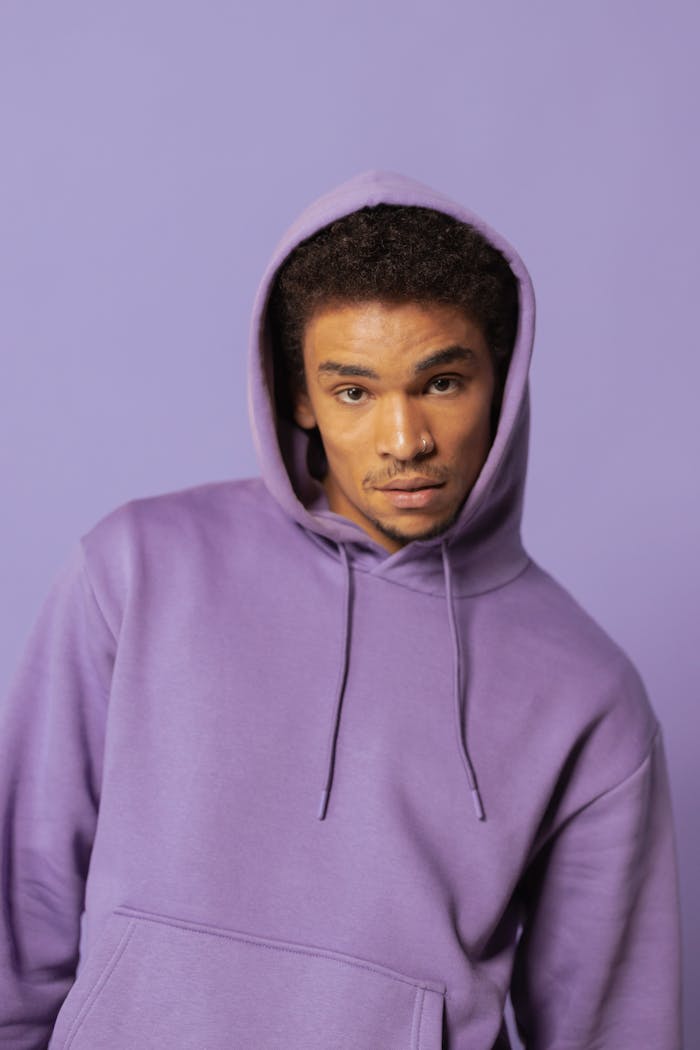 founder-img Stylish adult wearing purple hoodie, posing with confident expression. Perfect for fashion and lifestyle concepts.