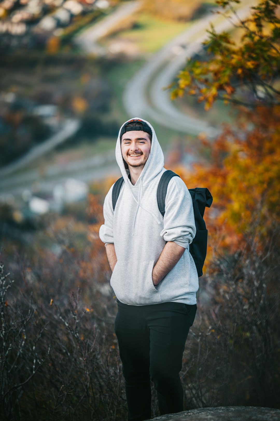 social-feed-img-01 Guy with a white hoodie smiling standing in the nature