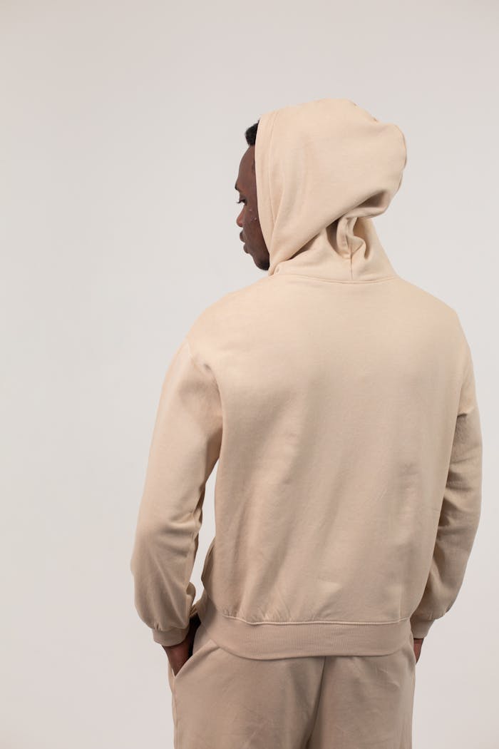 social-feed-img-01 Back view of African American man in hoodie and sweatpants standing with hands in pockets against white background