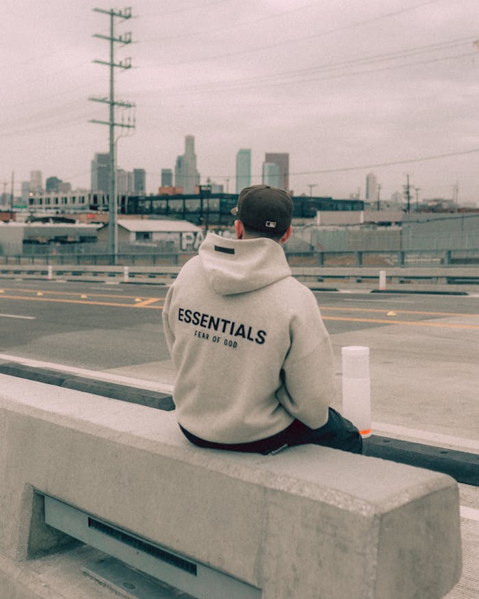 quality-assurance-02 Back view of a man in a sweatshirt sitting on a bench with Los Angeles skyline in the background.